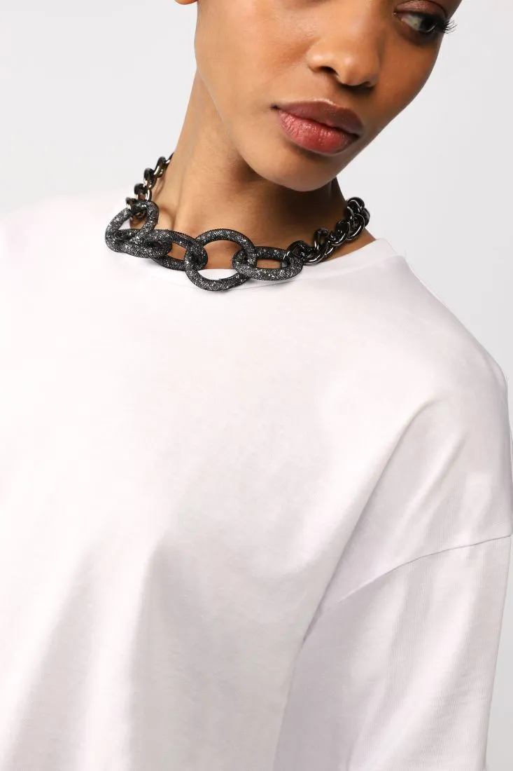 Oversized monochrome T-shirt with chain necklace.